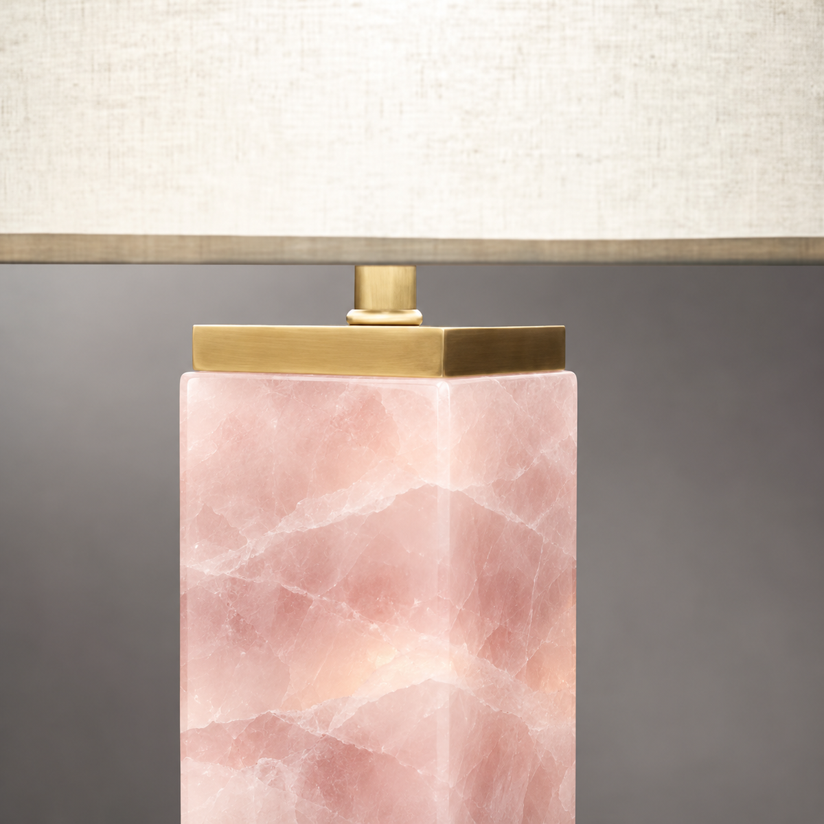 Close detail of the solid brass cap and rose quartz column of the Serra table lamp