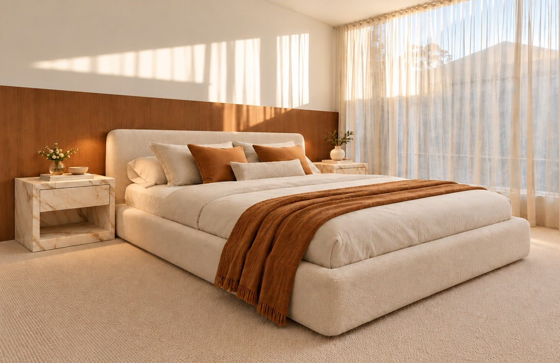 Pair of Evalina Calacatta marble bedside tables in a warm, sunlit bedroom
