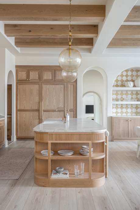 Brass pendant lights by Hudson Valley Lighting Group over a kitchen island