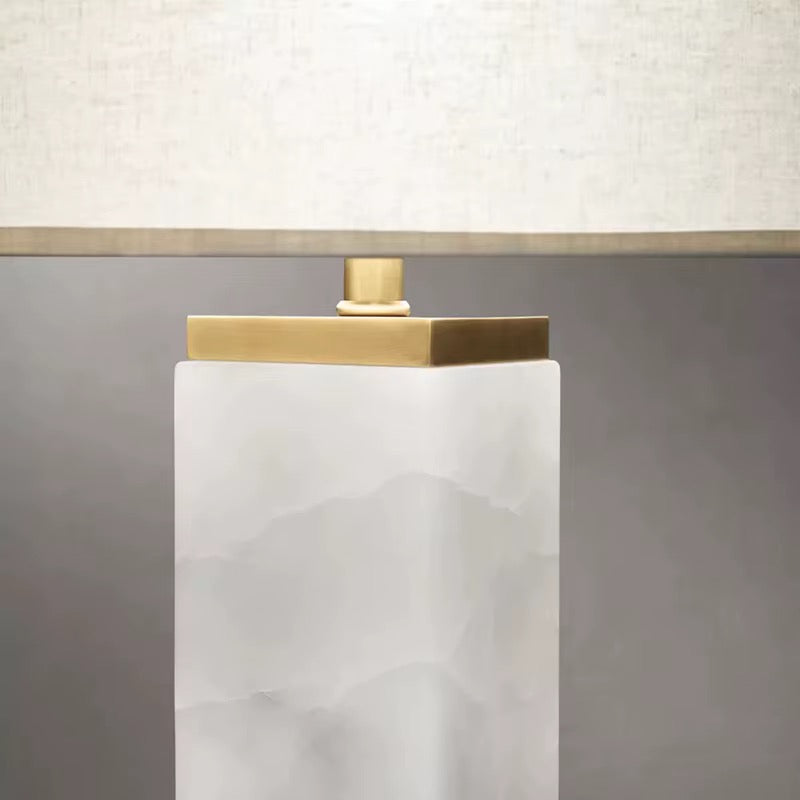 Close detail of the solid brass cap and white quartz column of the Serra table lamp