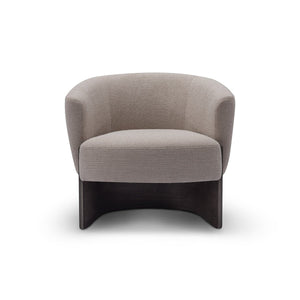 Maison Debrah Rexor curved tub armchair in warm grey woven fabric on an arched dark grey ash base