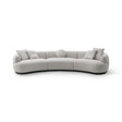 Maison Debrah Lunève curved three-section sofa in warm oatmeal fabric on a dark grey plinth