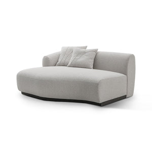 Maison Debrah Lunève curved three-section sofa in warm oatmeal fabric on a dark grey plinth — view 2