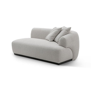 Maison Debrah Lunève curved three-section sofa in warm oatmeal fabric on a dark grey plinth — view 5