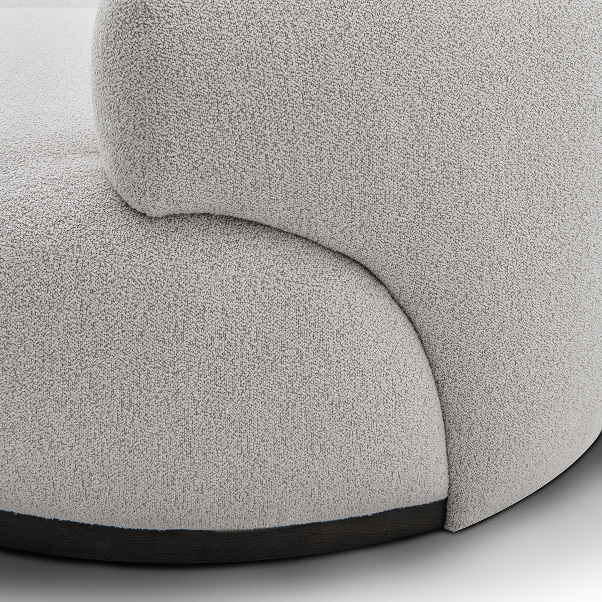 Maison Debrah Lunève curved three-section sofa in warm oatmeal fabric on a dark grey plinth — view 4