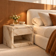 Evalina Calacatta marble bedside table with velvet-lined handle-free drawer, styled beside a boucle bed