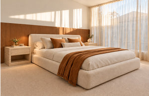 Pair of Evalina travertine bedside tables in a warm, sunlit bedroom